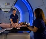 proton therapy patient being treated by two radiation therapists